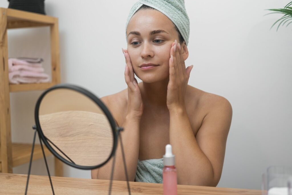 Woman admiring smooth, refreshed skin in a mirror after a skincare treatment