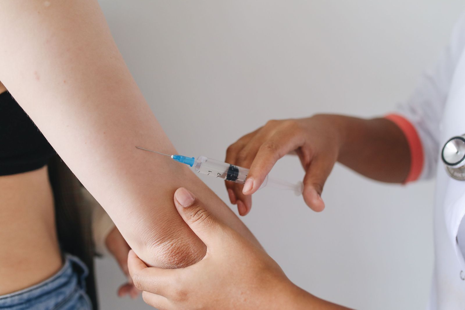 Clinician giving a quick vitamin injection into a patient’s upper arm