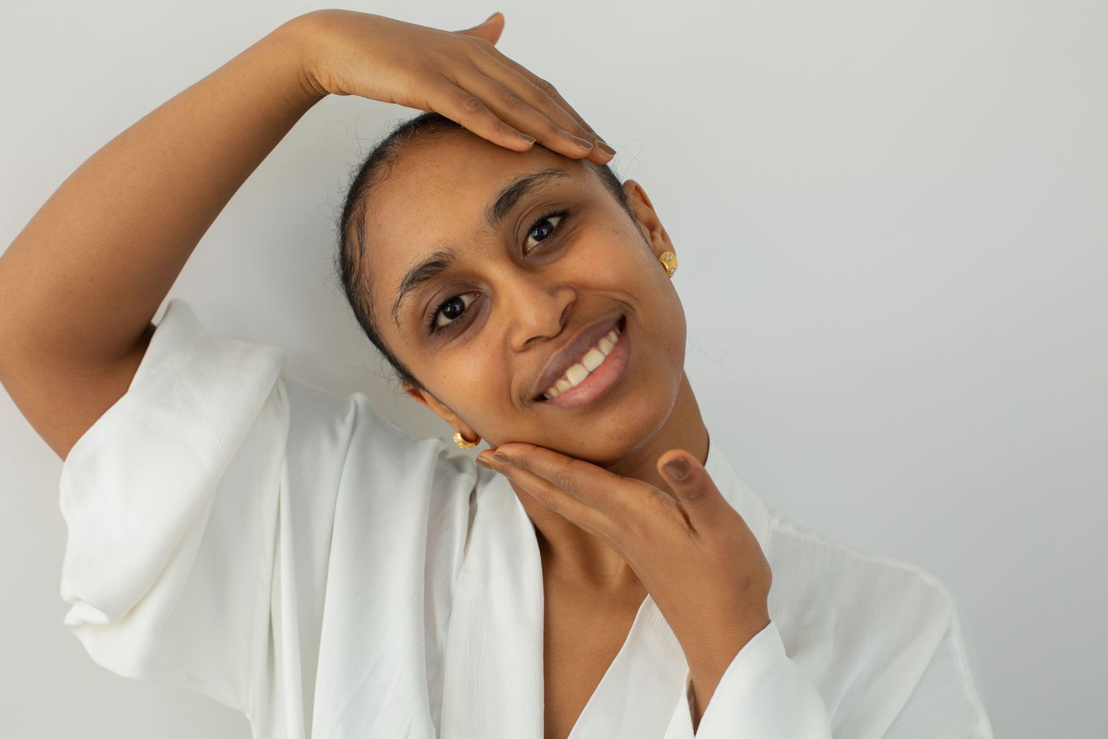 Guest in a robe smiling and touching her smooth, freshly exfoliated skin