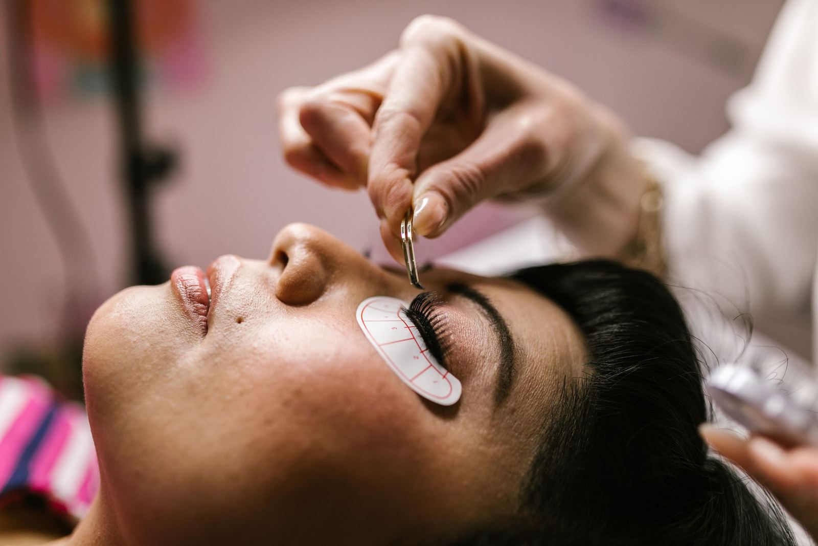 A relaxed guest with eyes closed receiving a lash lift and tint treatment