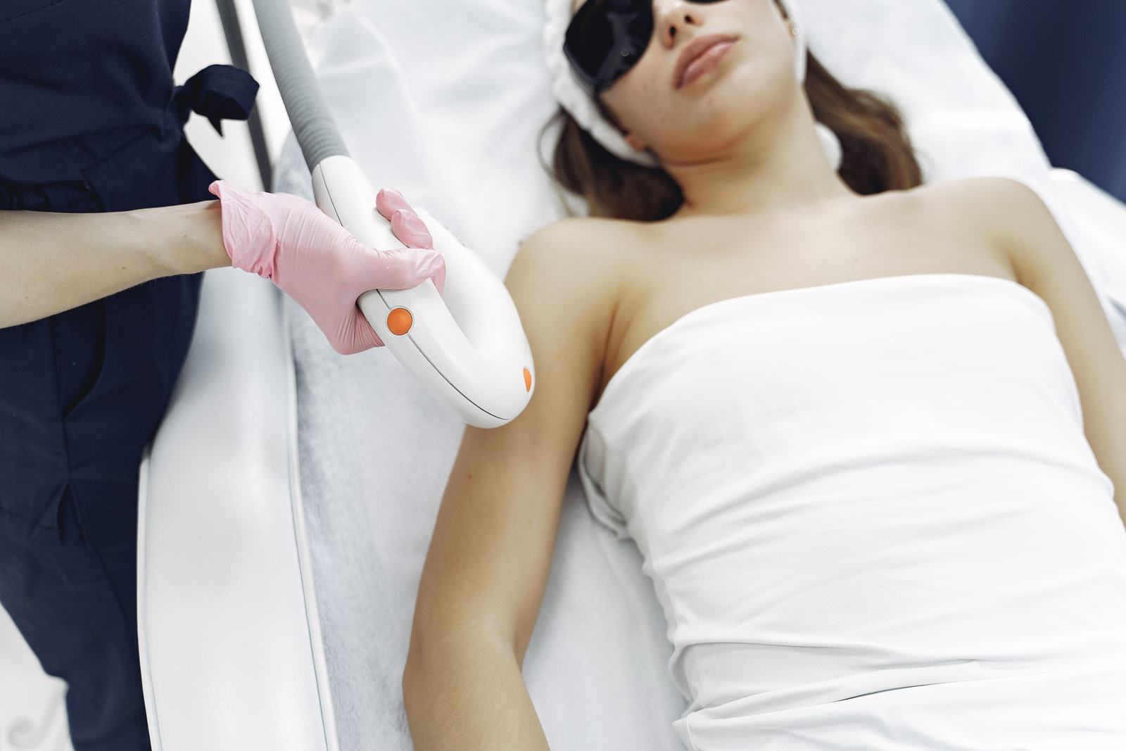 Laser hair removal treatment being performed on a client's underarm