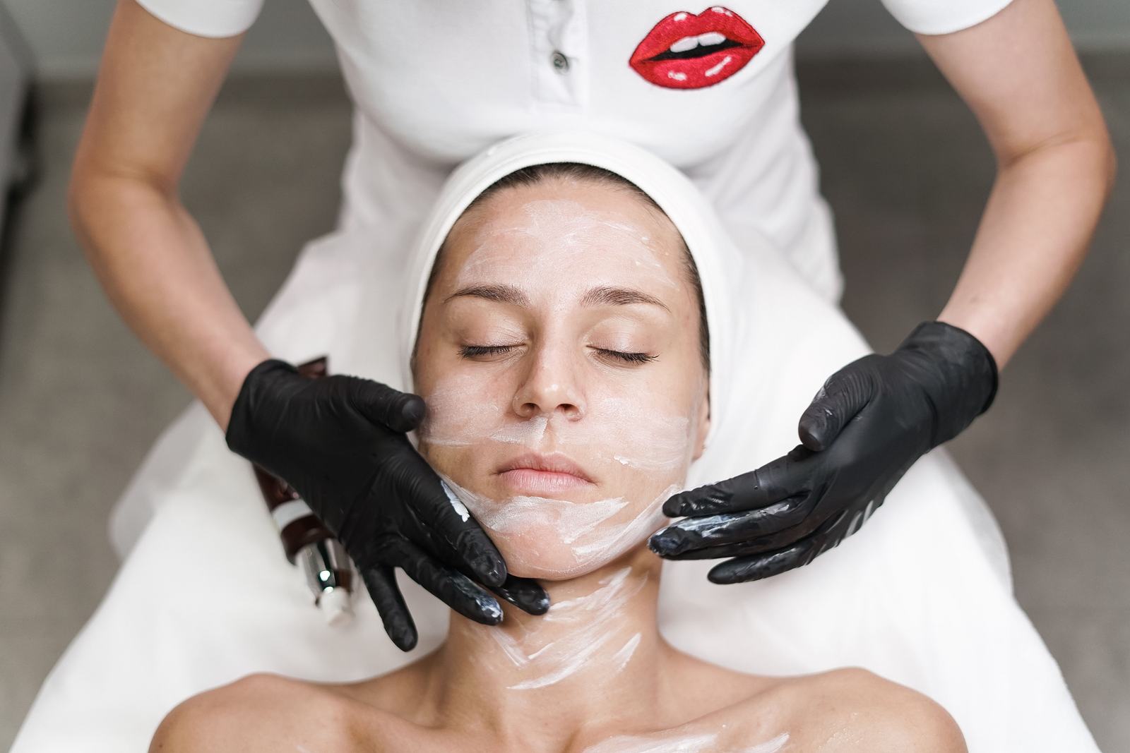 Woman receiving a professional facial treatment with a mask being applied
