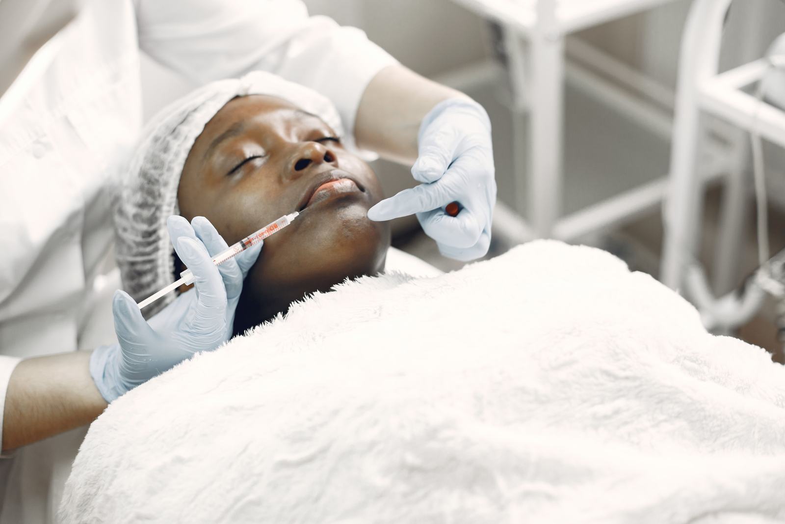 Person receiving a cosmetic facial injection in a medical treatment room
