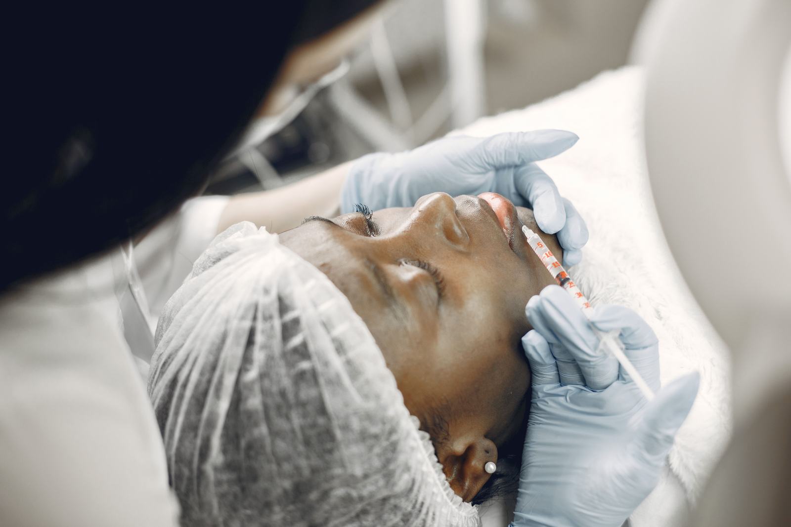 Close up of a lip filler injection being performed in a clinical setting