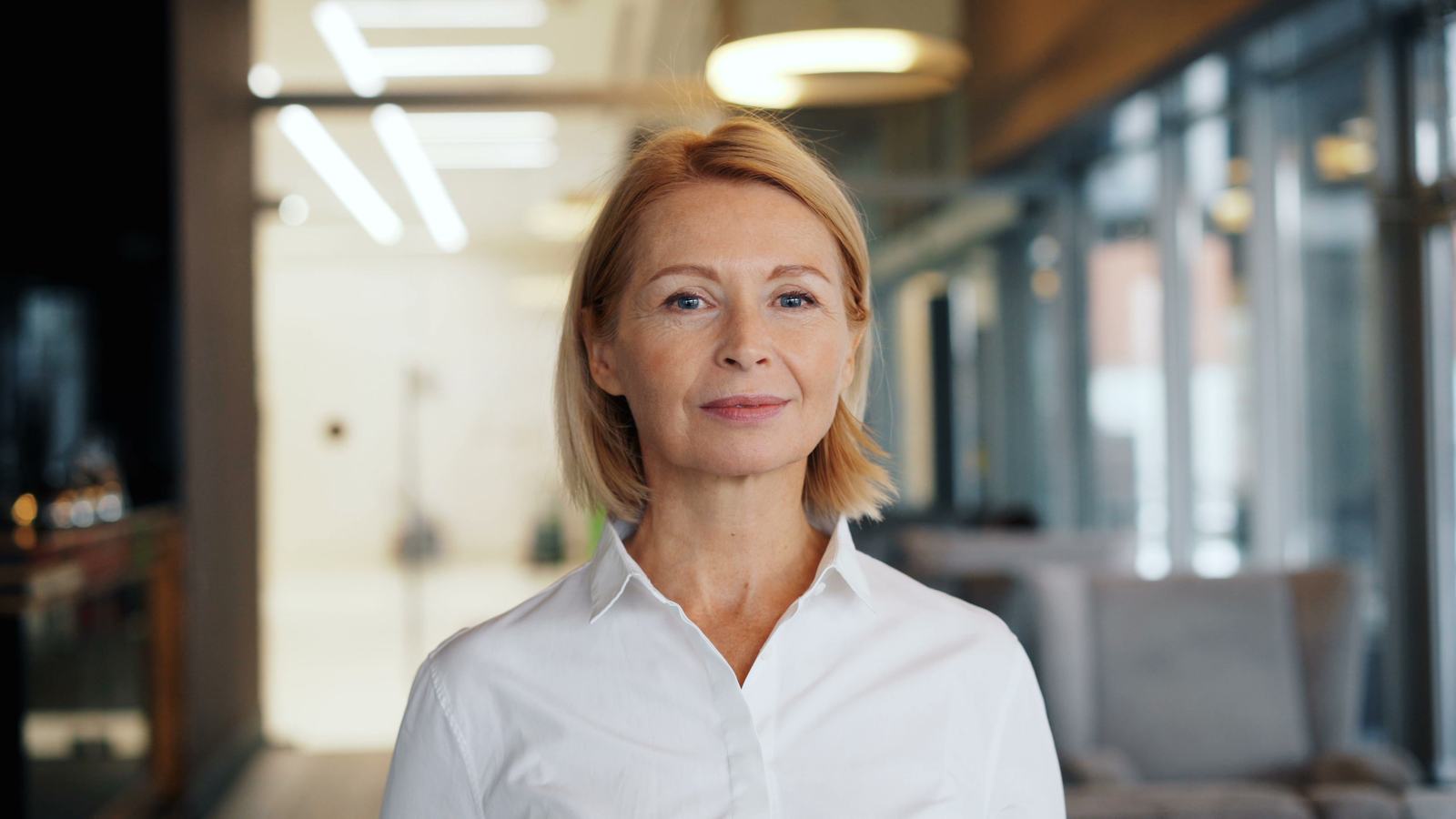 Confident woman in her fifties smiling in a bright modern setting