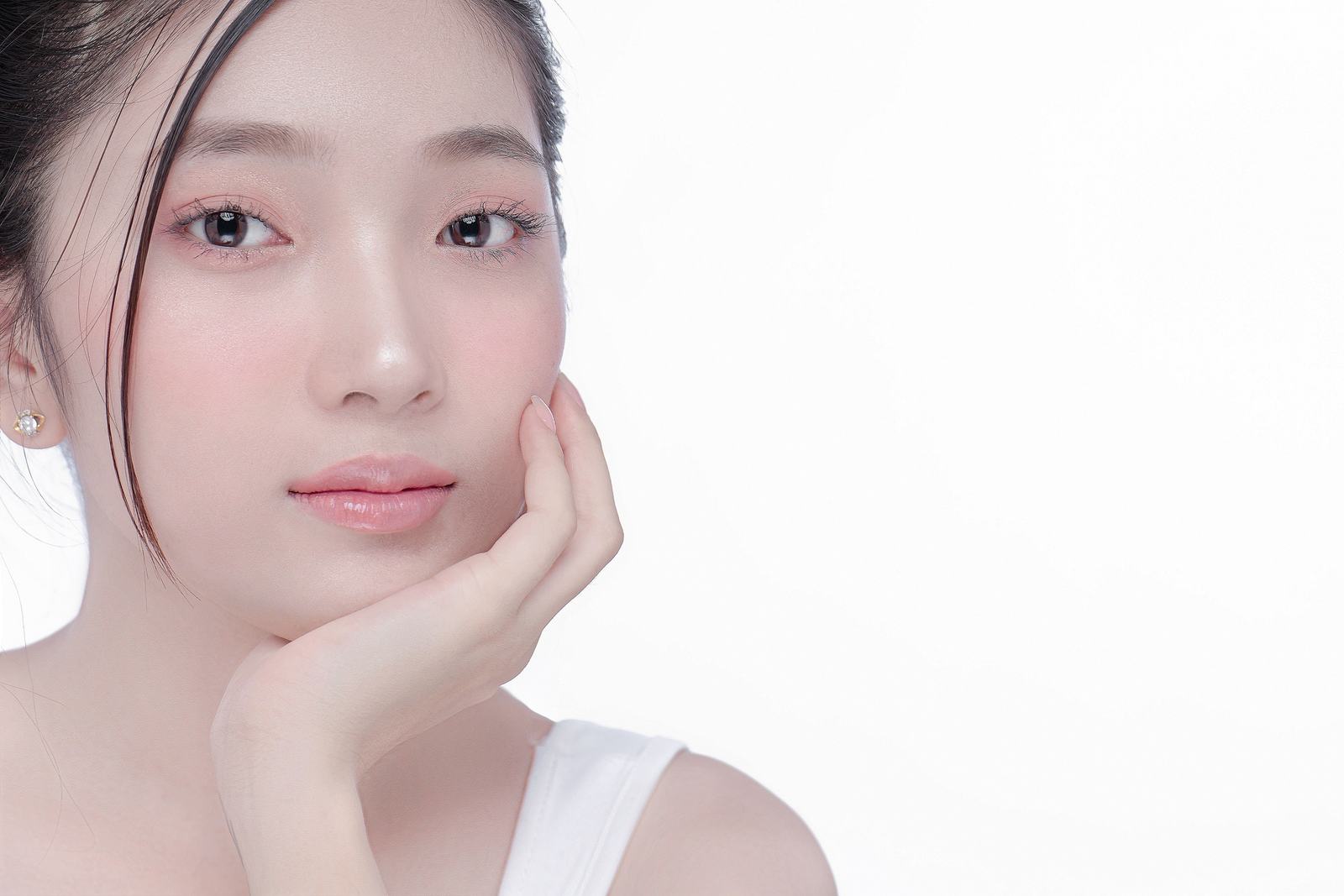 Close up portrait of a woman with clear hydrated skin in soft studio light