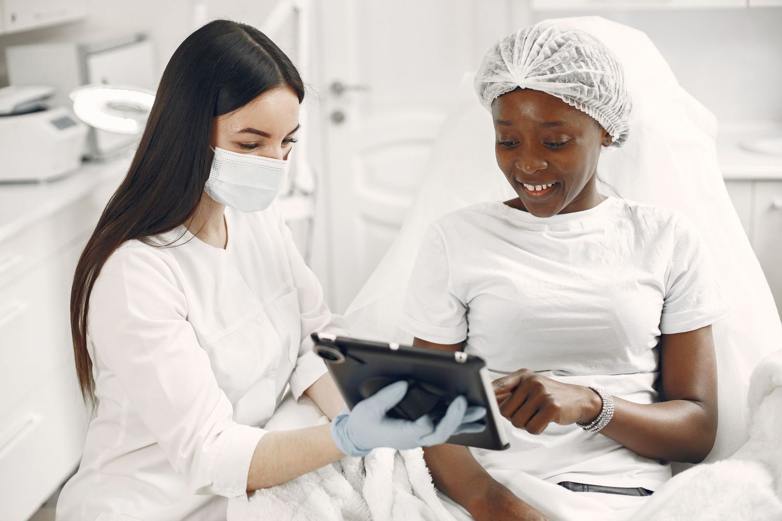 A provider and a client looking at a tablet together during a skincare consultation in a treatment room